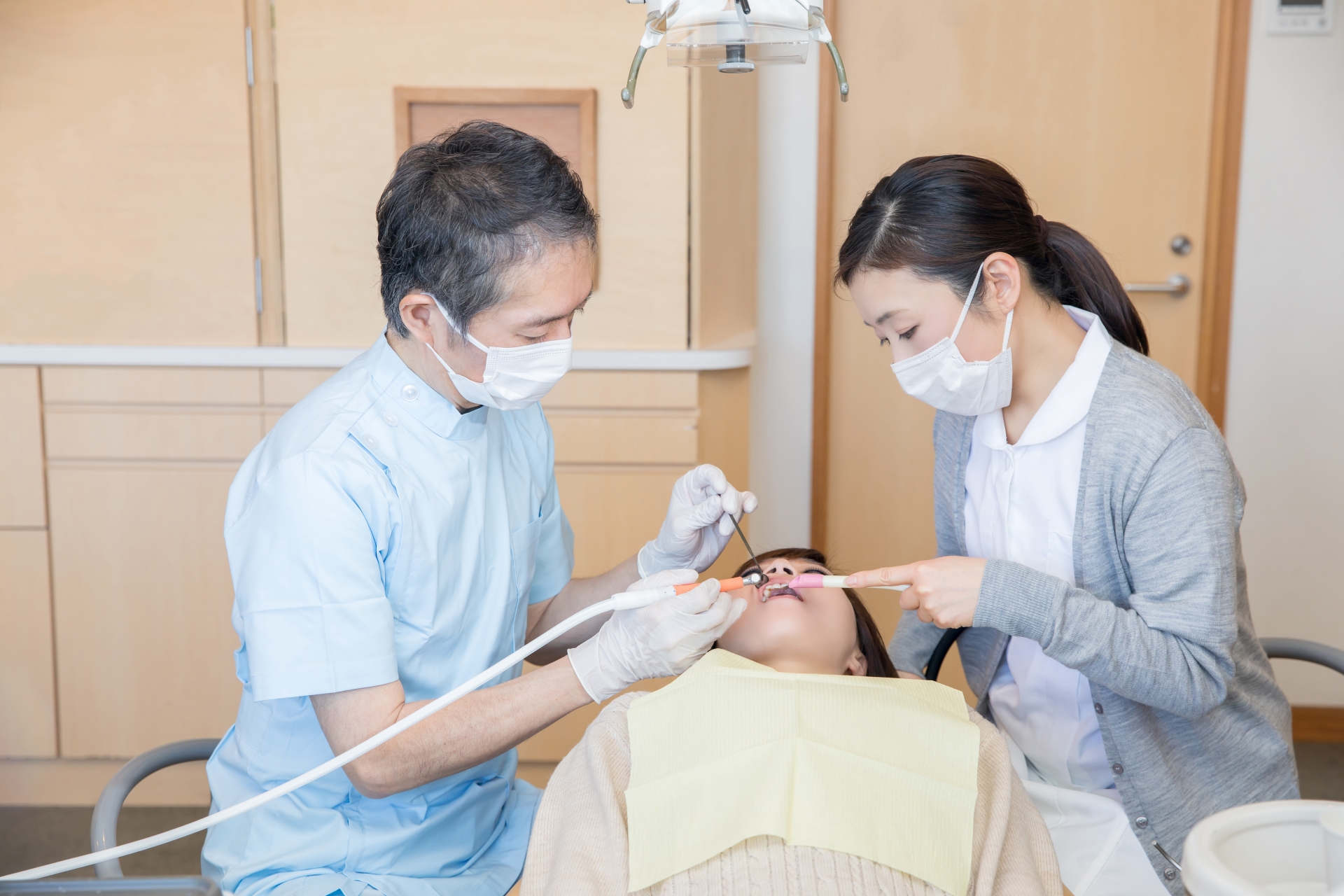 歯医者で治療する女性