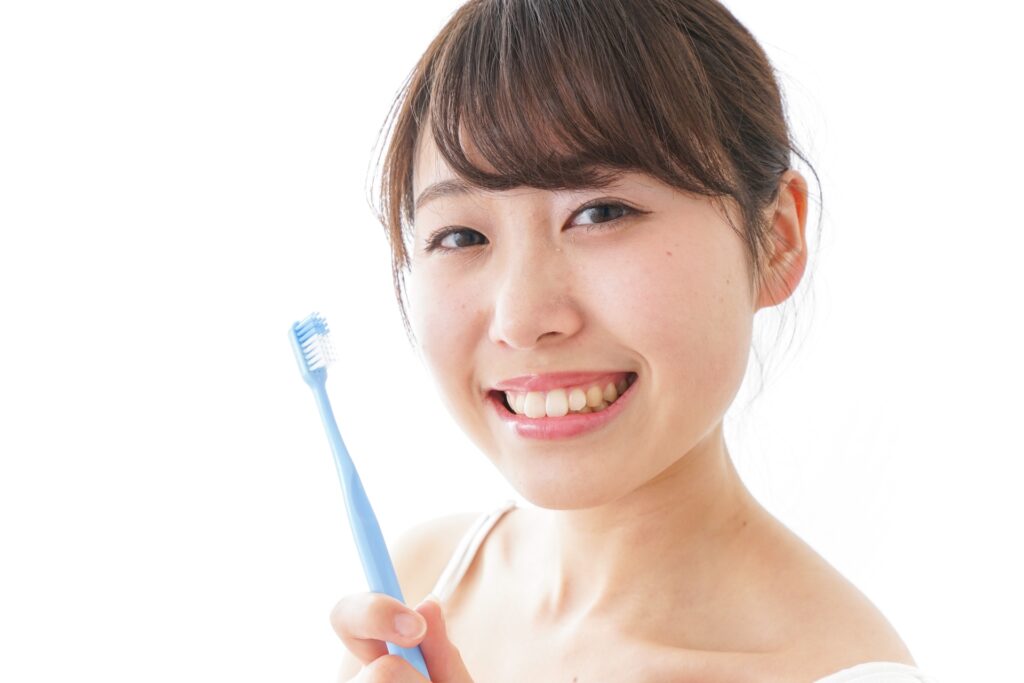 歯ブラシを持つ笑顔の女性