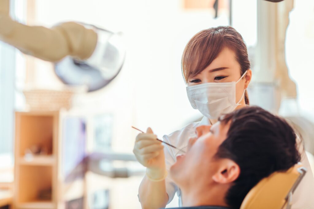 口腔内を診察する歯科衛生士